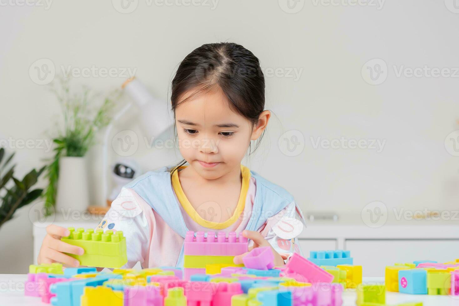 little girl is happy Playing colorful block puzzles. in the white room photo