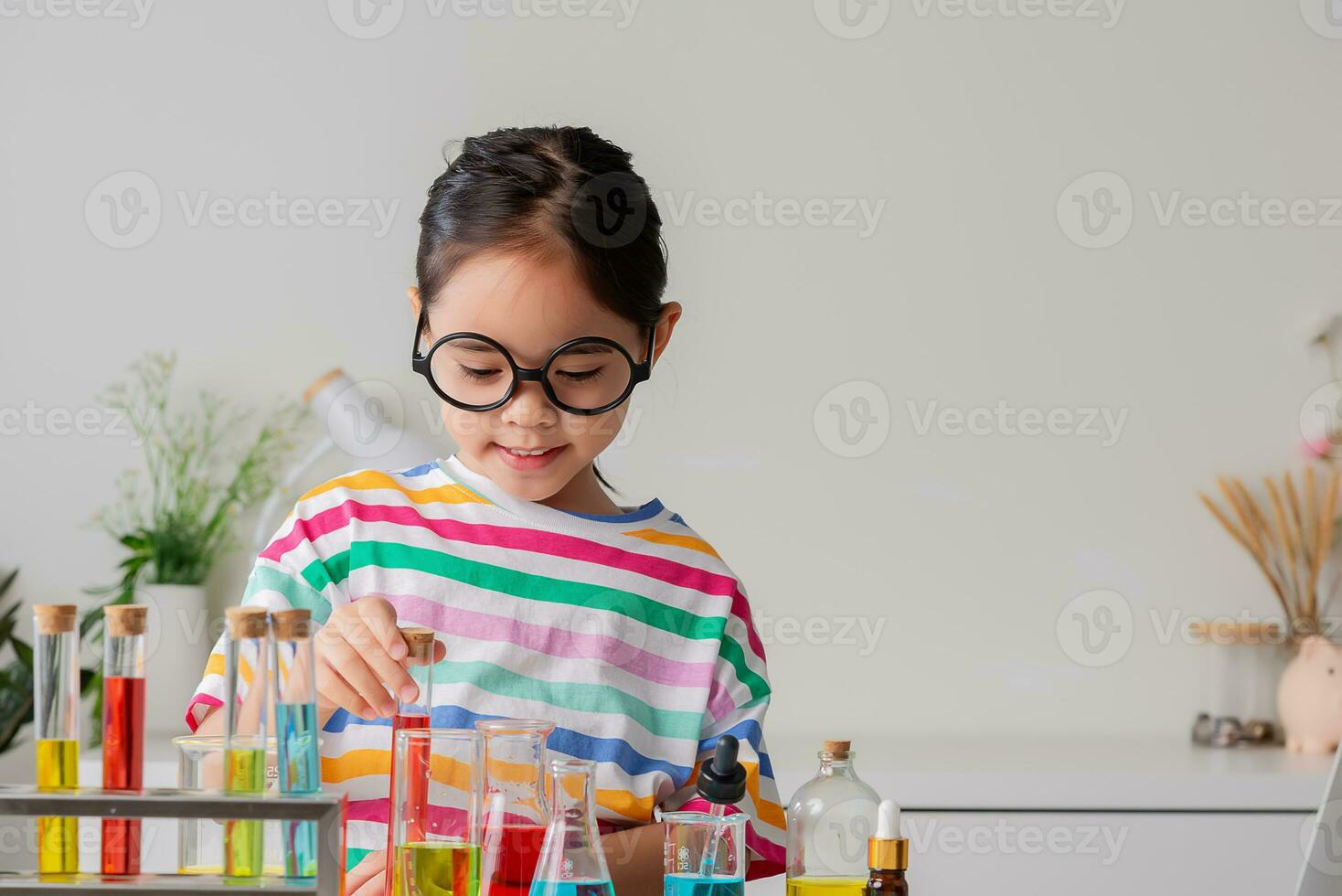 Asian little girl working with test tube science experiment in white classroom photo