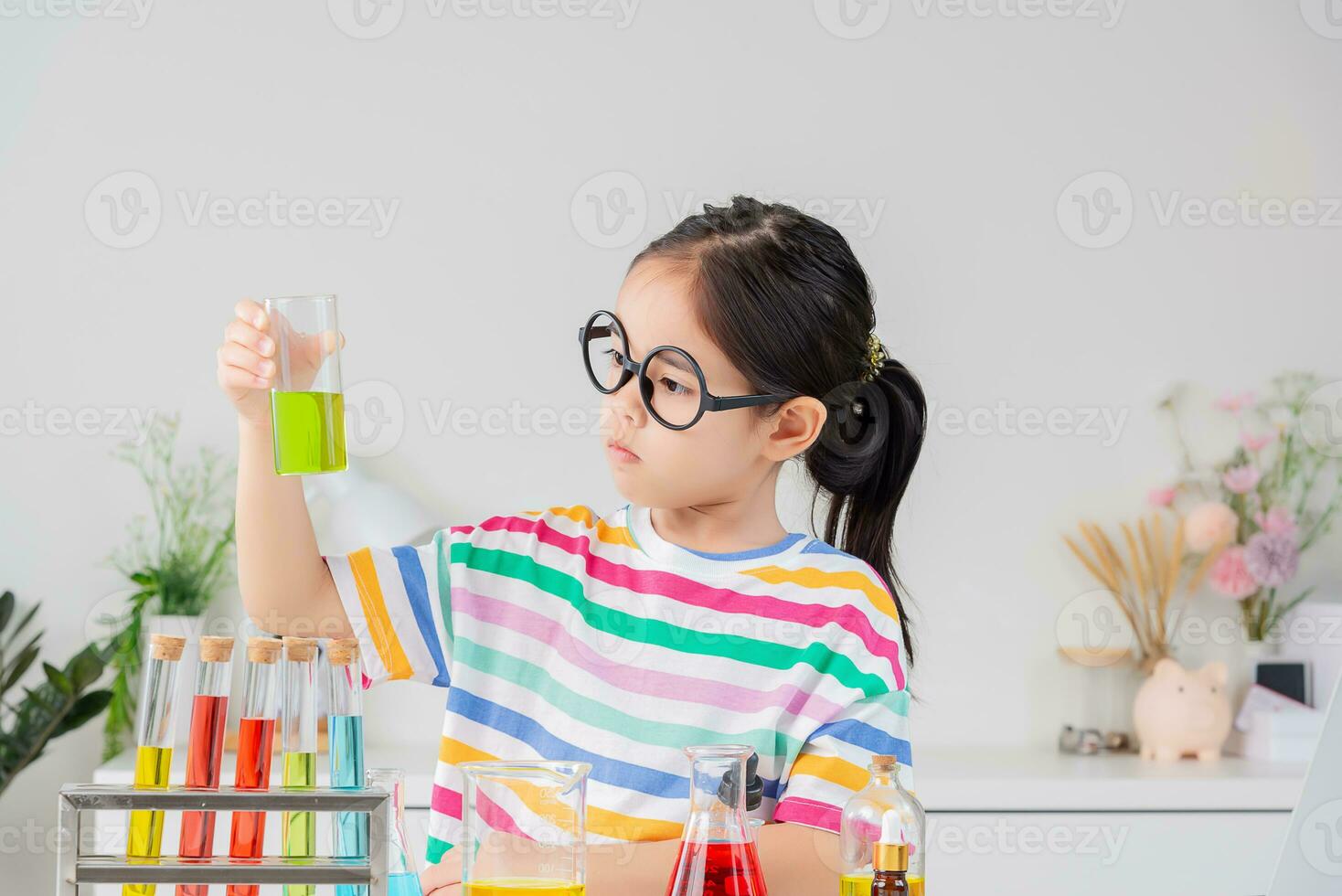 Asian little girl working with test tube science experiment in white classroom photo