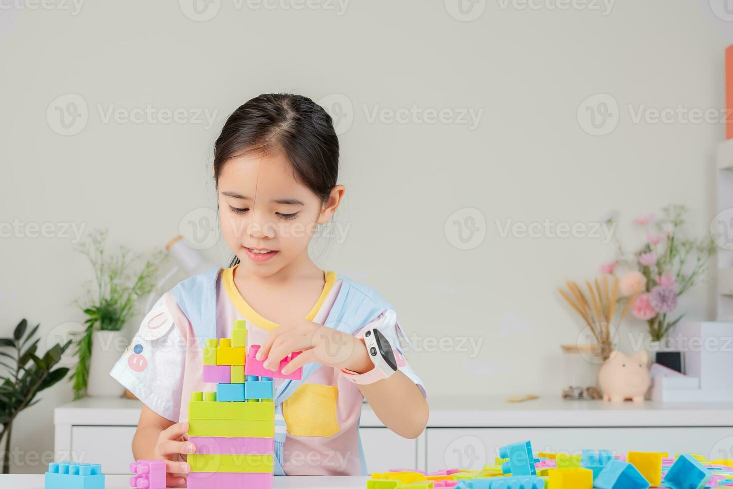 little girl is happy Playing colorful block puzzles. in the white room photo
