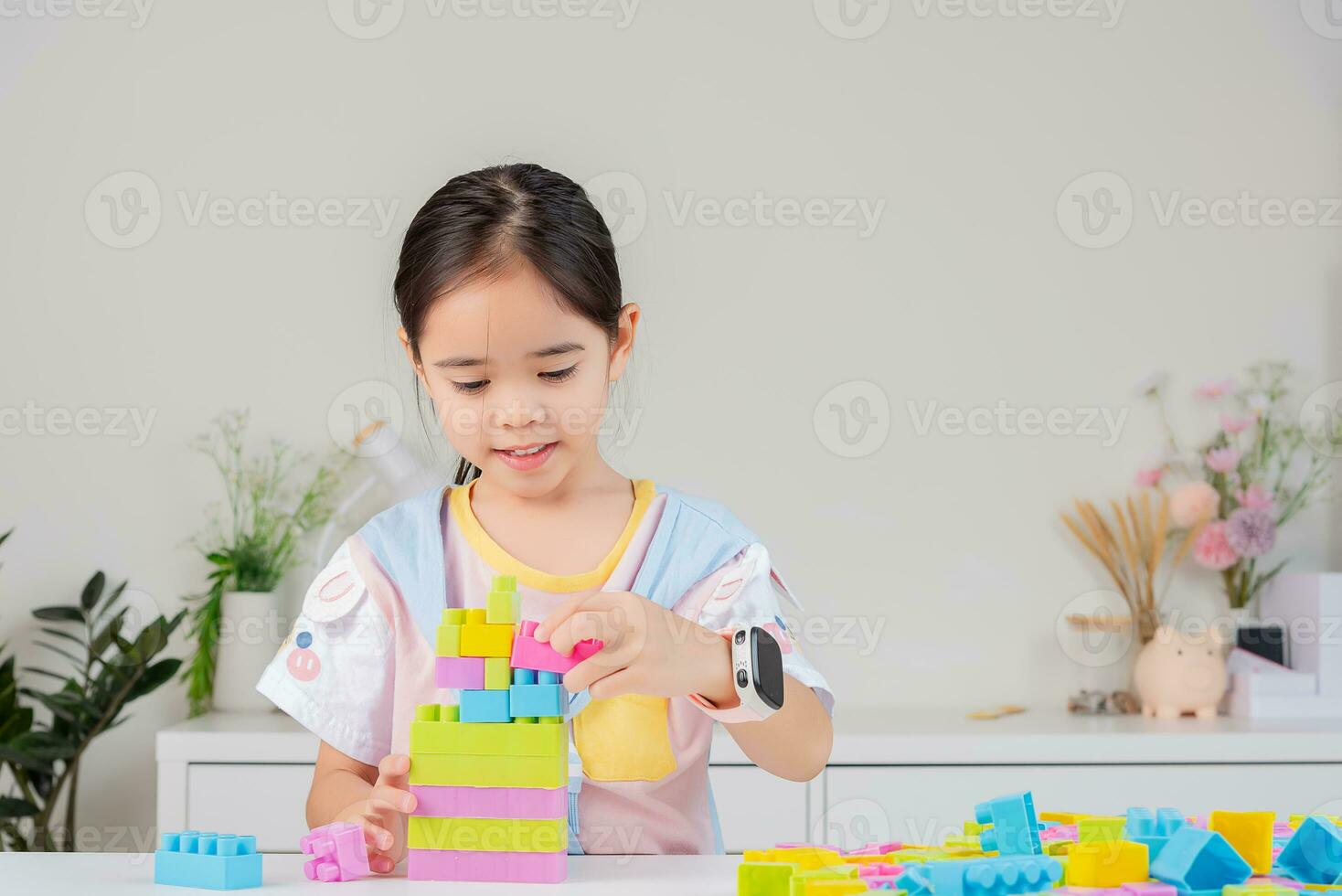 little girl is happy Playing colorful block puzzles. in the white room photo