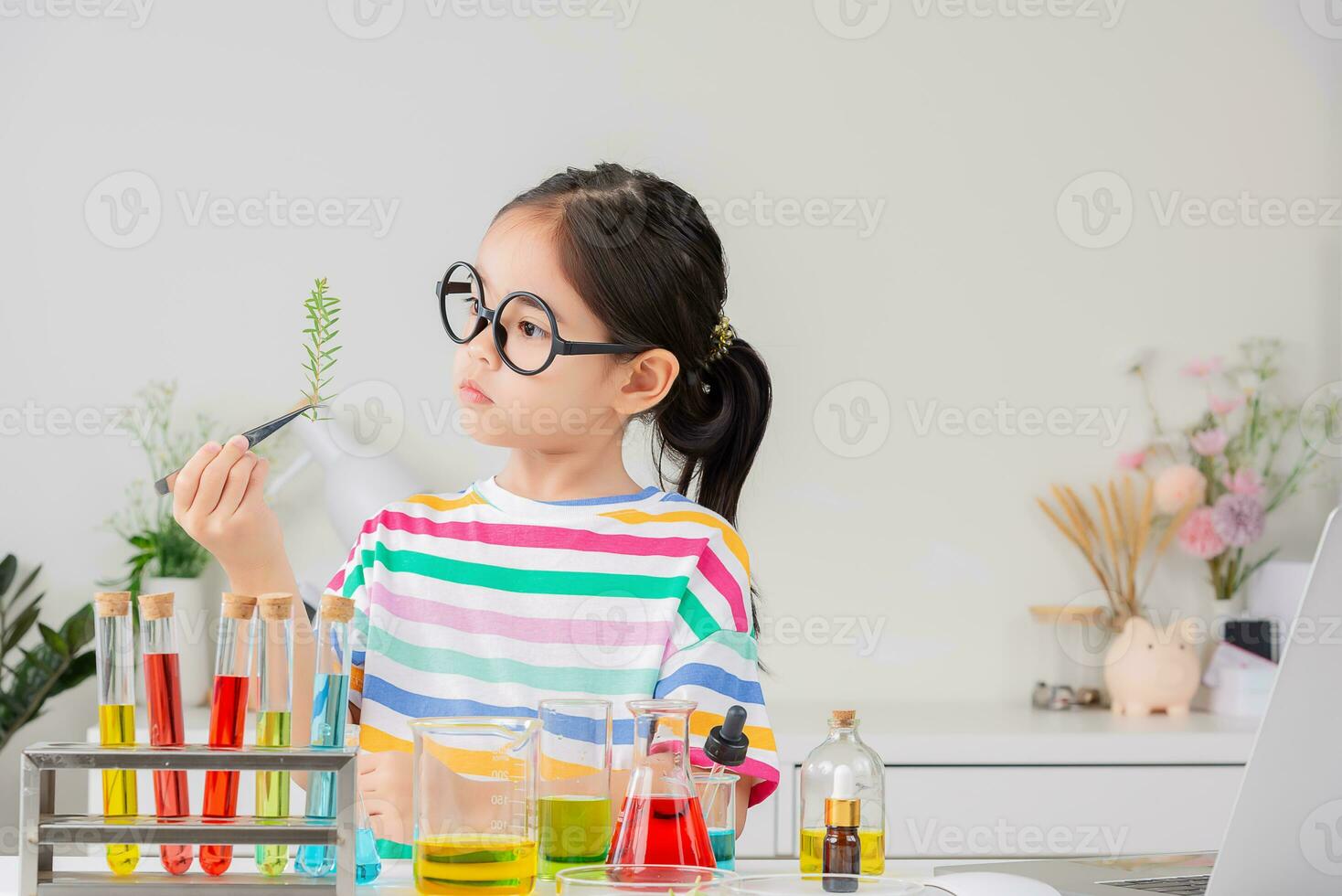 Asian little girl working with test tube science experiment in white classroom photo