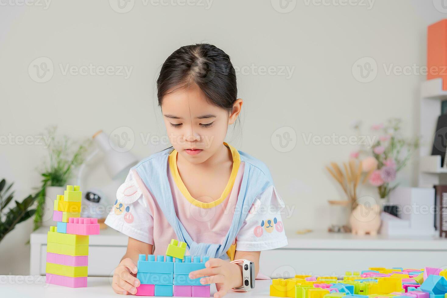 little girl is happy Playing colorful block puzzles. in the white room photo