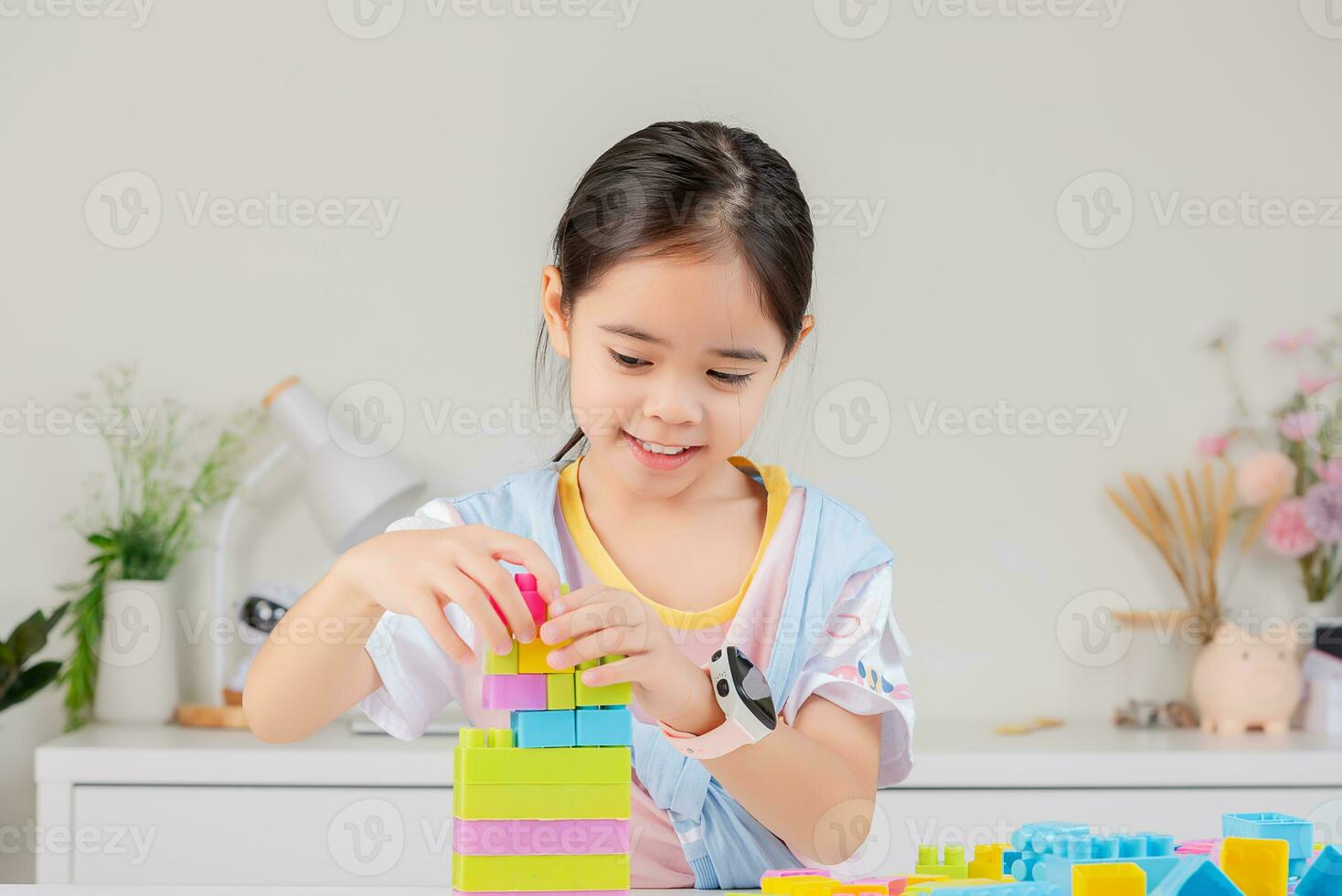 little girl is happy Playing colorful block puzzles. in the white room photo