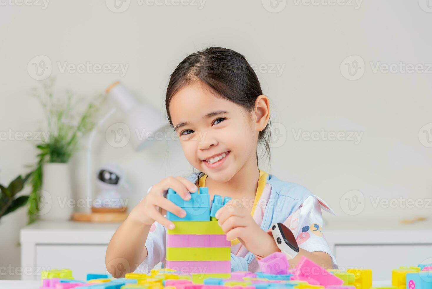 little girl is happy Playing colorful block puzzles. in the white room photo