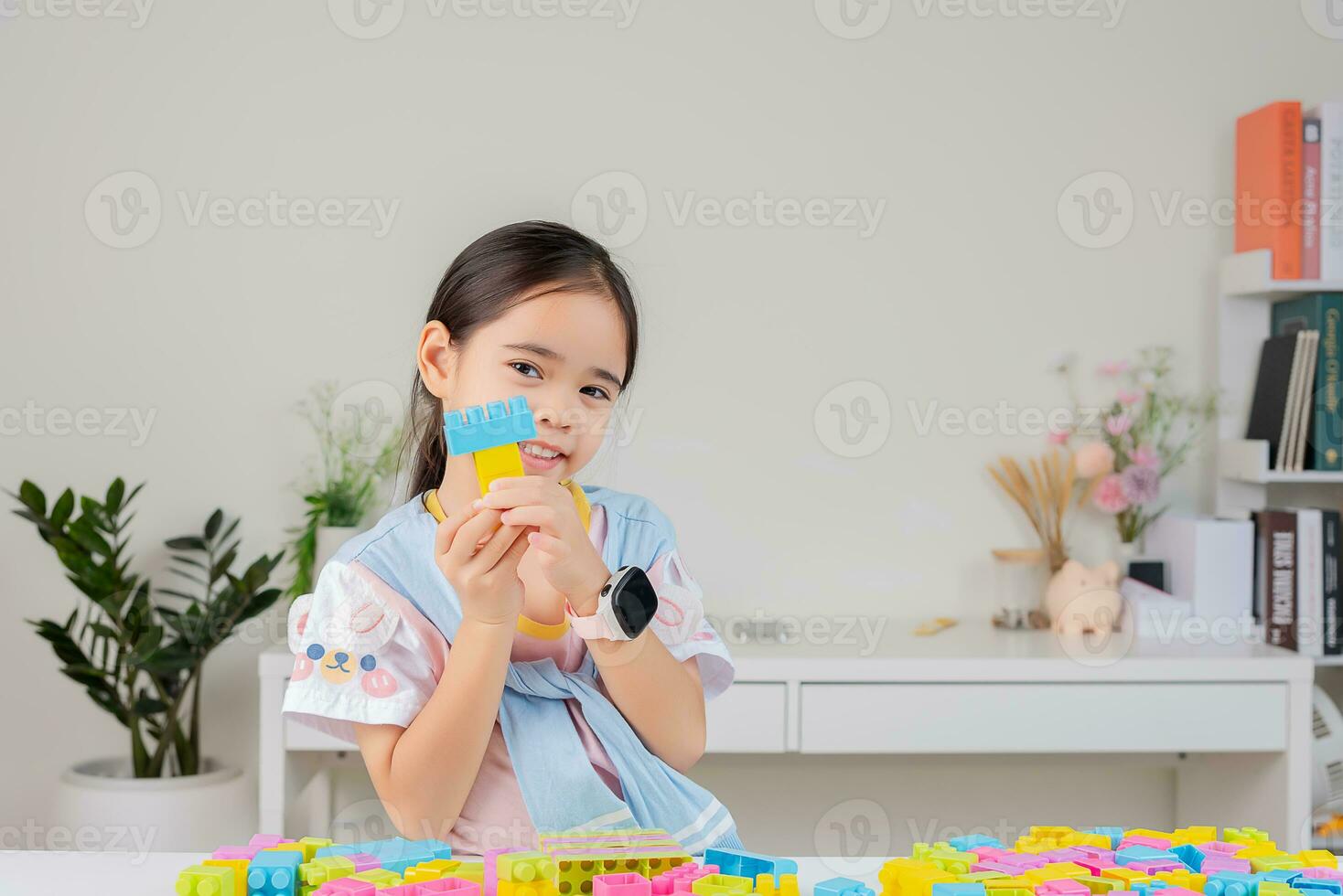 little girl is happy Playing colorful block puzzles. in the white room photo