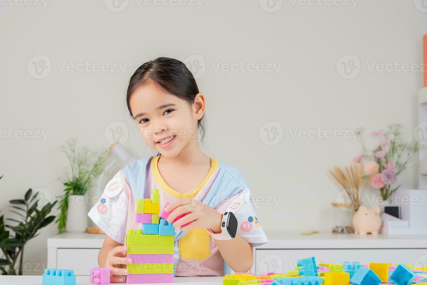 little girl is happy Playing colorful block puzzles. in the white room photo