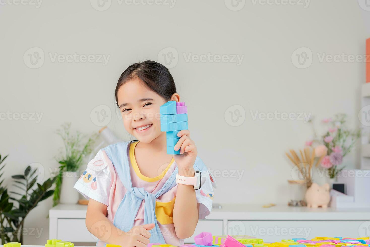 little girl is happy Playing colorful block puzzles. in the white room photo