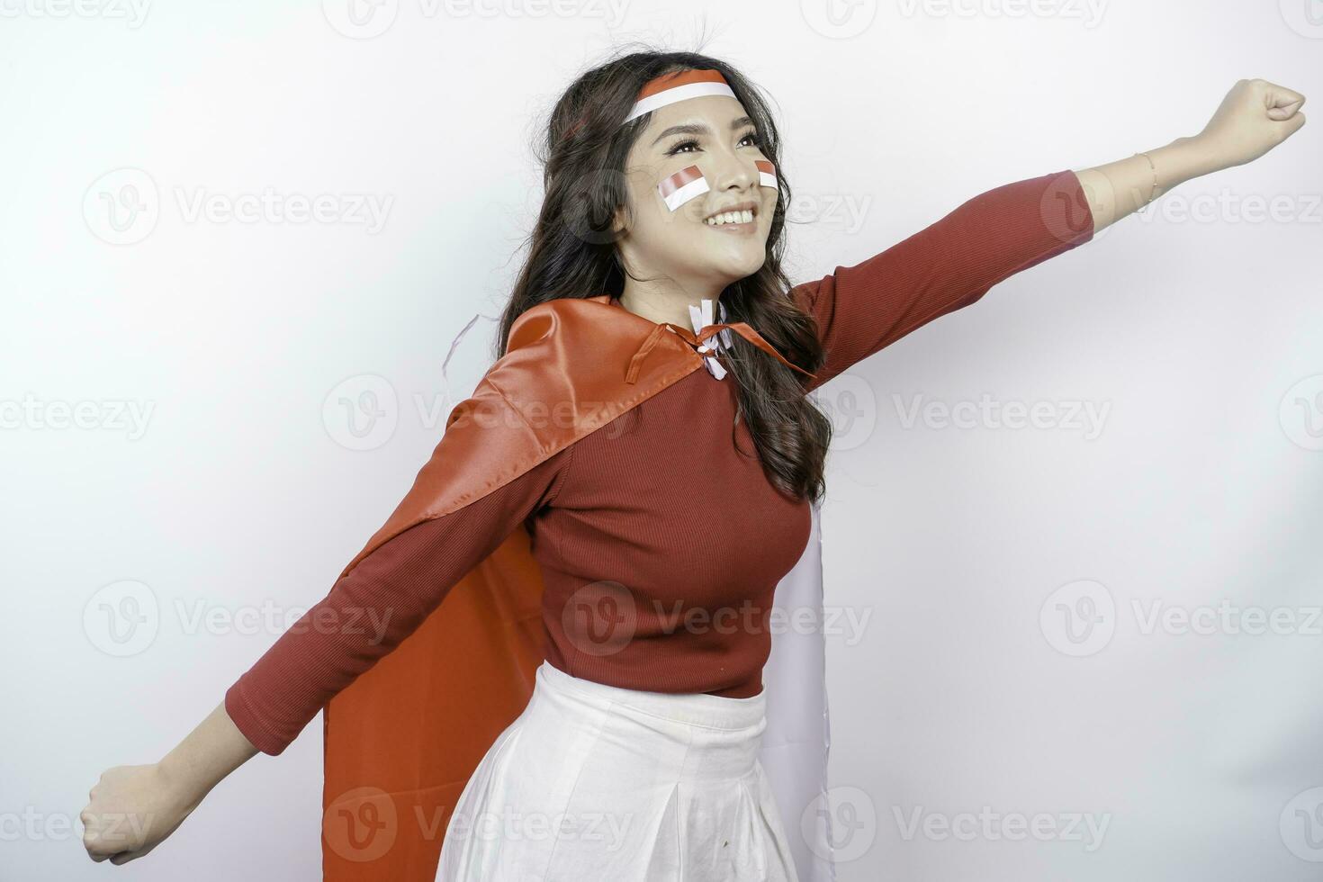 Happy smiling Indonesian woman holding Indonesia's flag to celebrate Indonesia Independence Day isolated over white background. photo