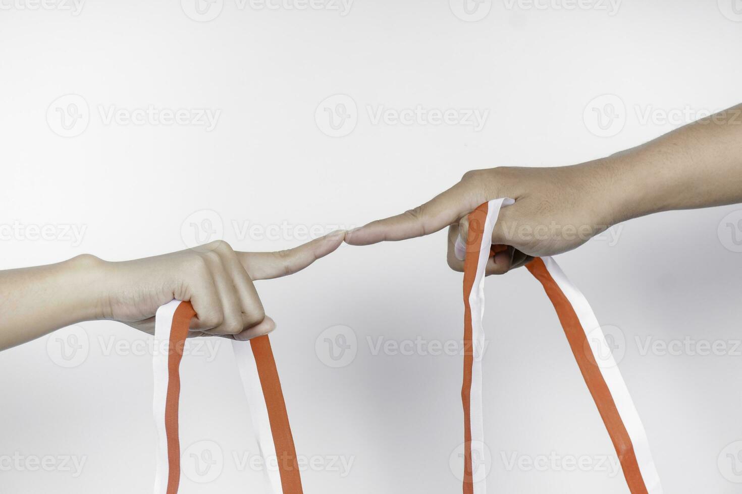 hands put together holding Indonesian red and white ribbon. Indonesia's independence day concept photo