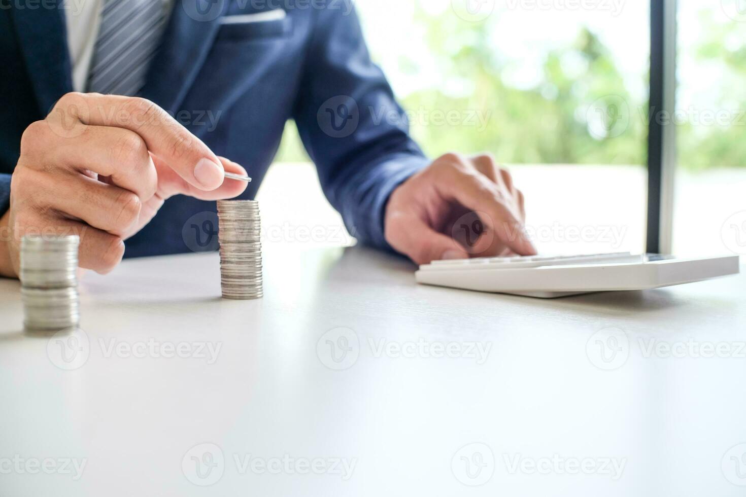 Saving money. Businessman Accountant verify growing business and saving money stacking coins with calculator. Accountancy Concept. photo