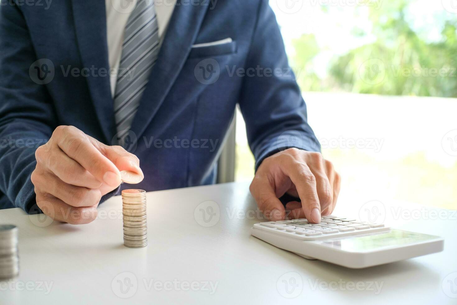 Saving money. Businessman Accountant verify growing business and saving money stacking coins with calculator. Accountancy Concept. photo