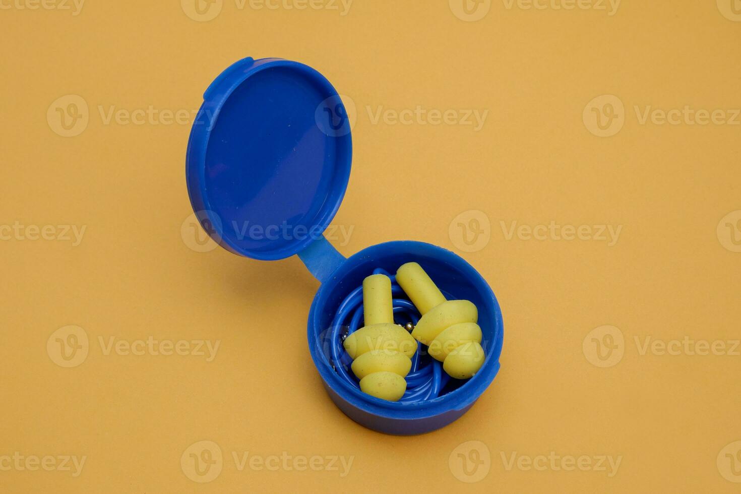 yellow silicone ear plugs with ear plug storage tubes isolated on yellow background photo