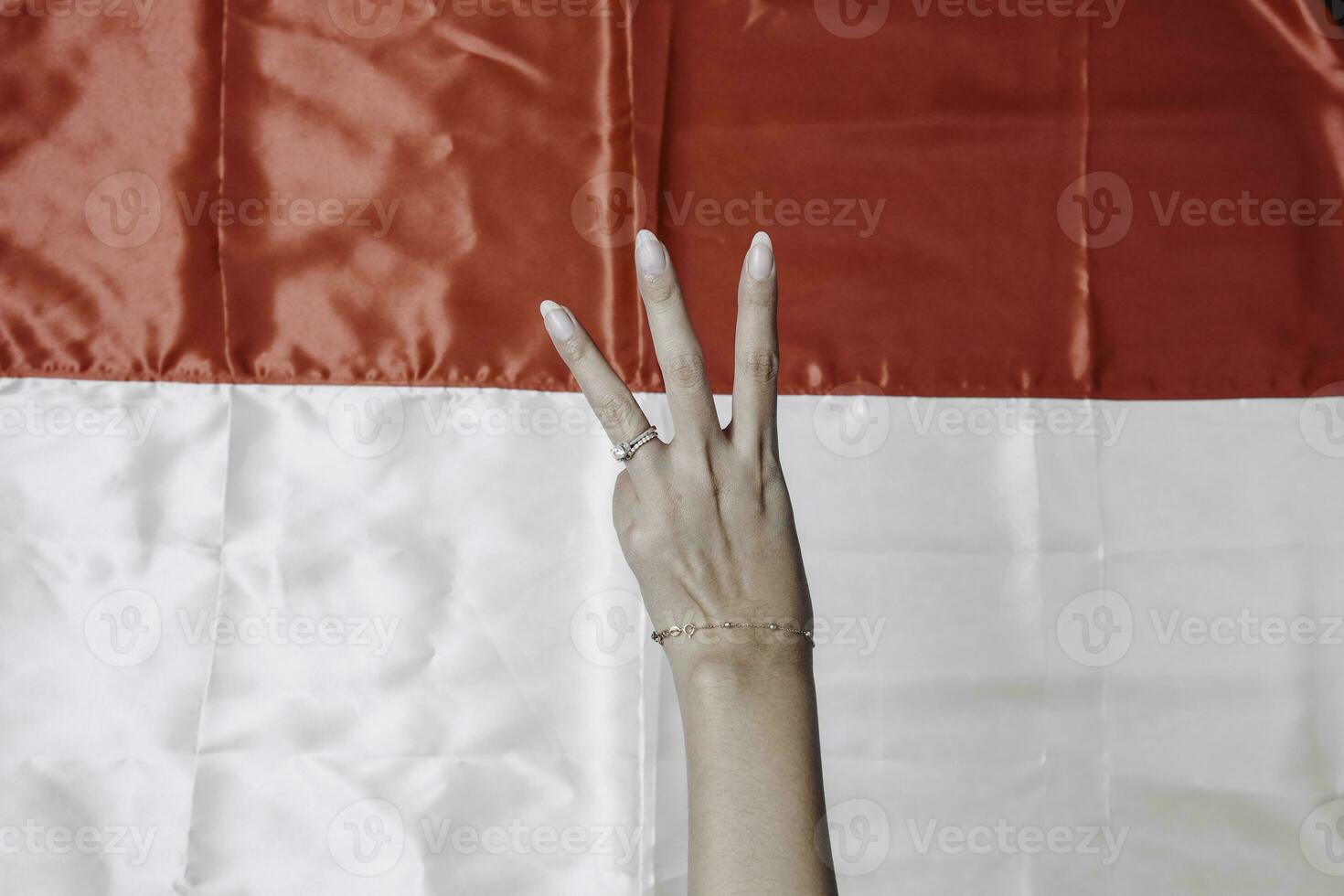 Hands gesturing signs of number isolated by Indonesian red and white flag. Indonesia's independence day concept photo