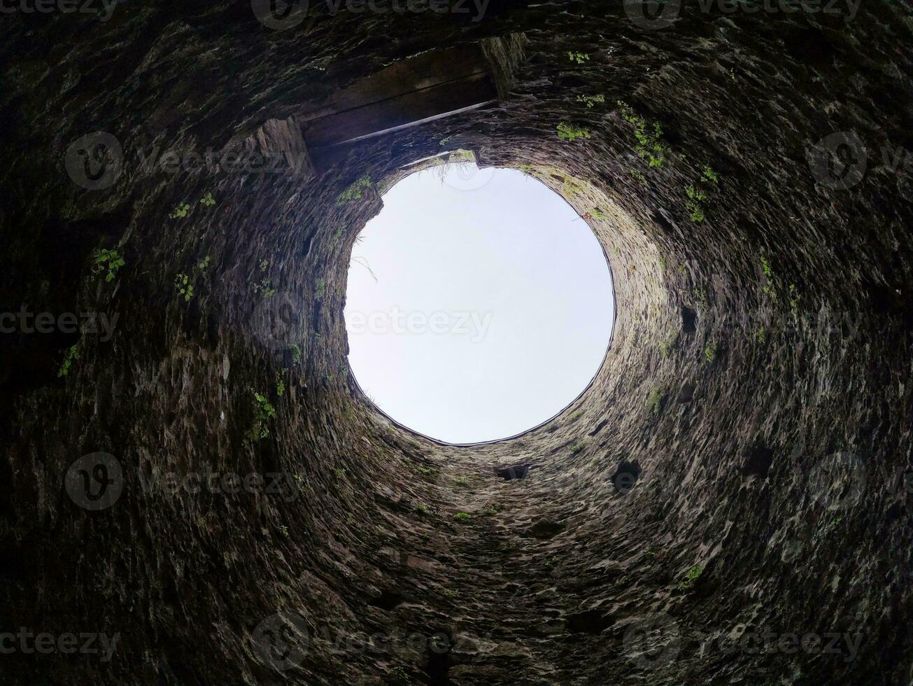 Stone well hole, old construction from inside, fall down in the well photo