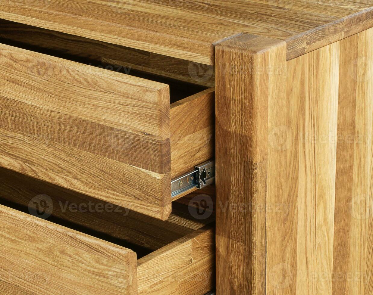 Opened wooden drawers with sliders close view photo, wooden eco furniture elements background. Solid wood furniture details photo