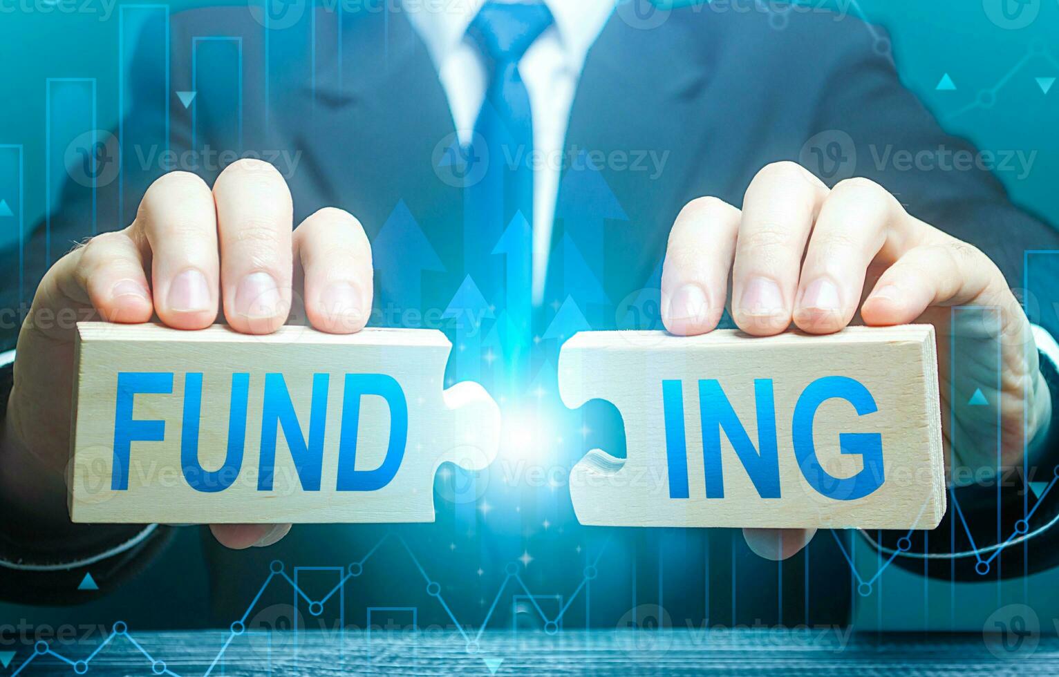 Businessman connects puzzles with the word funding. Investing in a business project, raising funds. Providing financial resources. Credit, donations, taxes, support grants, savings and subsidies. photo
