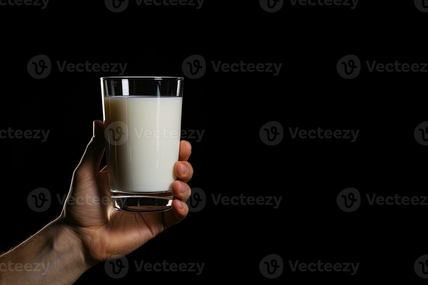 Hand holding a glass of fresh milk isolated on black background with copy space. ai generated photo