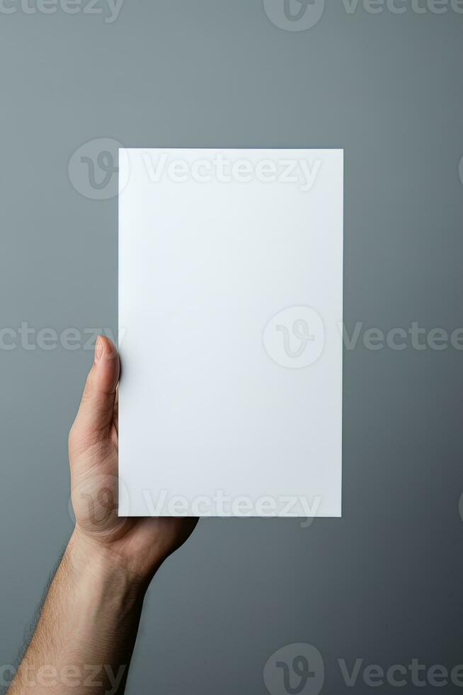 A human hand holding a blank sheet of white paper or card isolated on grey background. ai generated photo