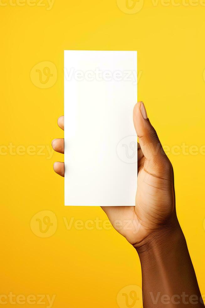 A human hand holding a blank sheet of white paper or card isolated on yellow background. ai generated photo