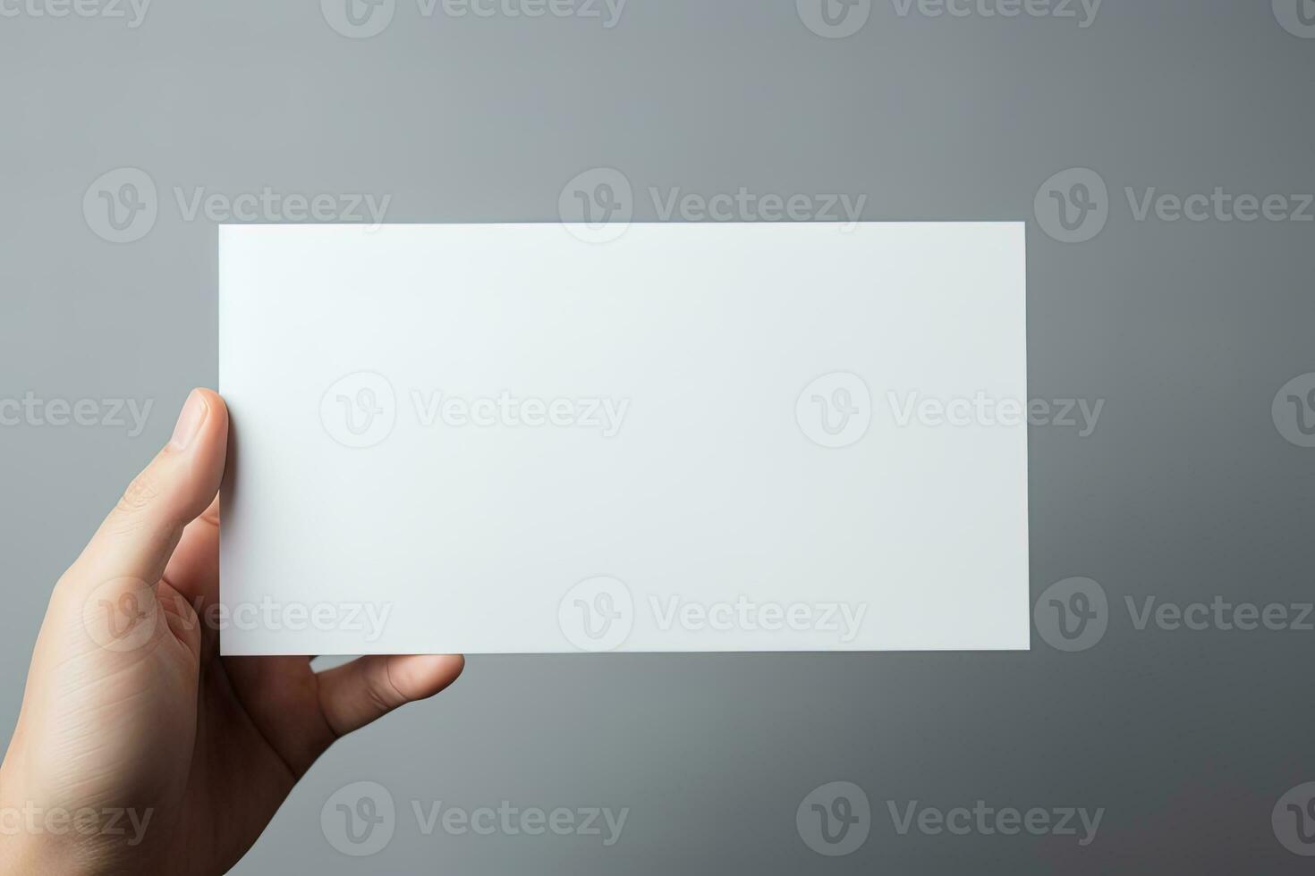 A human hand holding a blank sheet of white paper or card isolated on grey background. ai generated photo