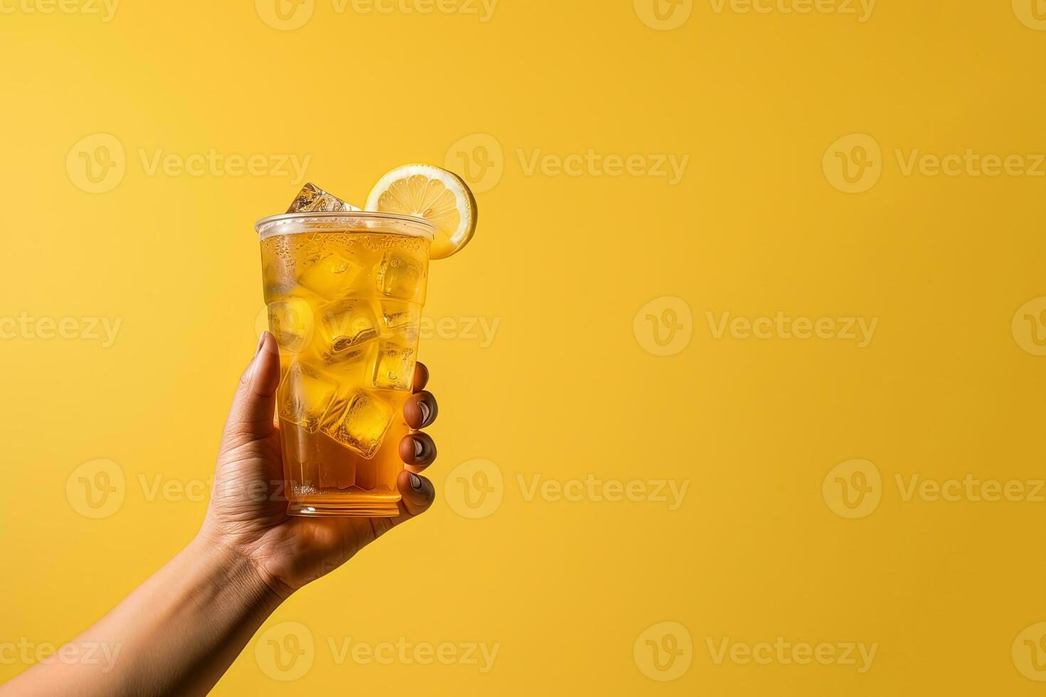 A hand holding takeaway plastic cup of delicious iced lemon tea isolated on yellow background with copy space. ai generated photo
