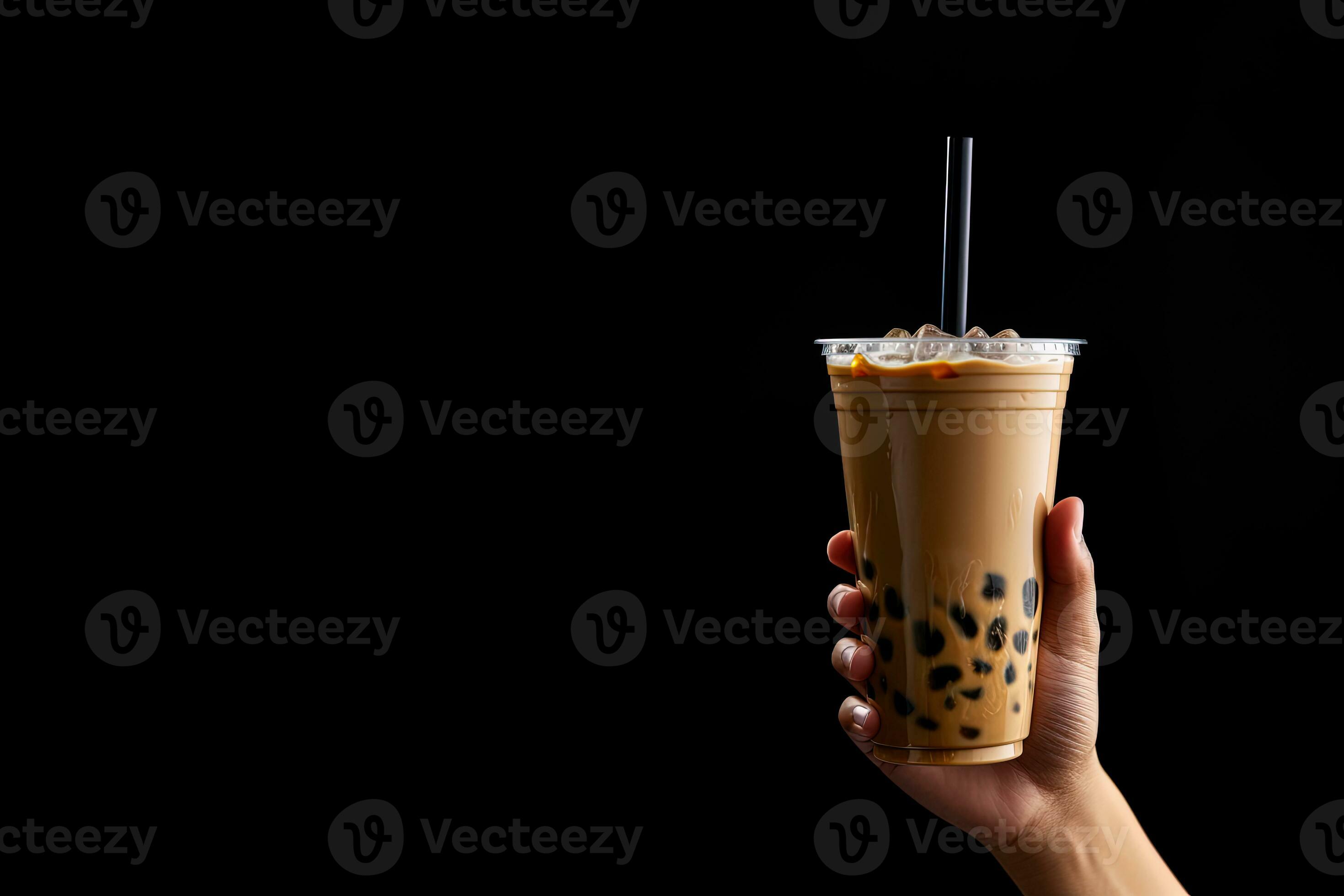 A hand holding takeaway plastic cup of delicious iced bubble milk tea