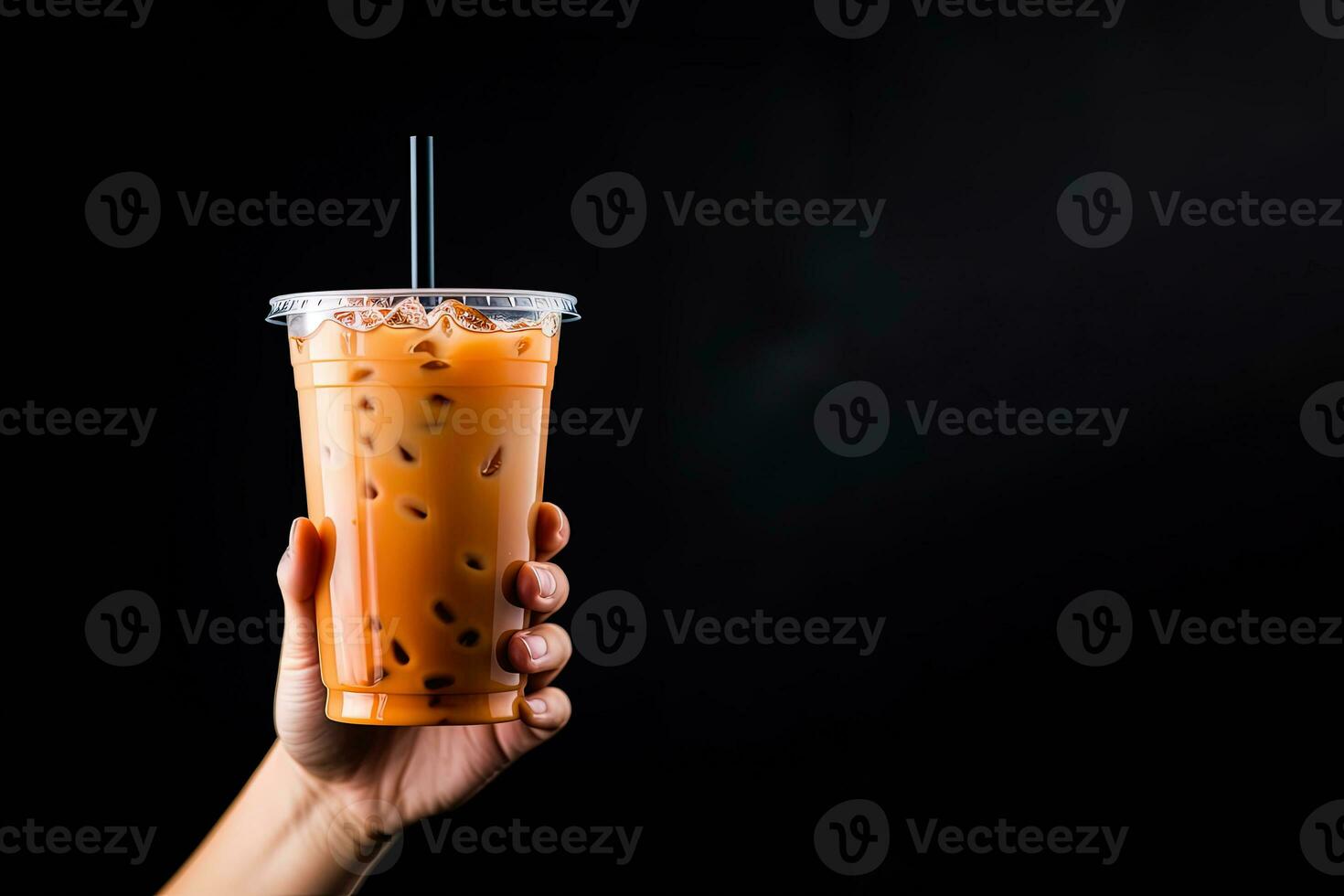 A hand holding takeaway plastic cup of delicious iced bubble milk tea and black pearls isolated on black background with copy space. ai generated photo