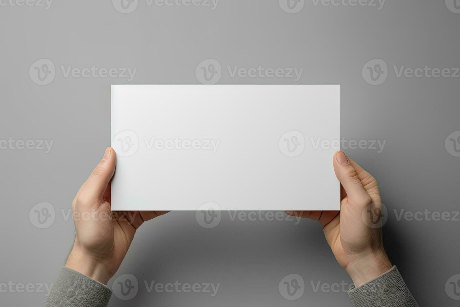 A human hand holding a blank sheet of white paper or card isolated on grey background. ai generated photo