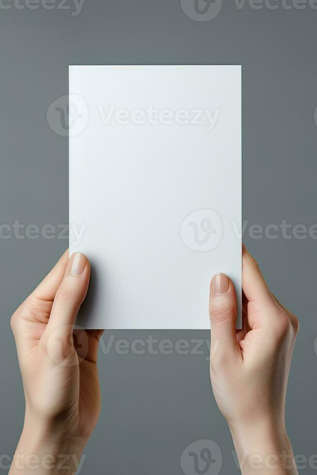 A human hand holding a blank sheet of white paper or card isolated on grey background. ai generated photo