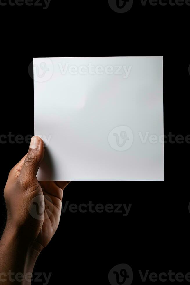 A human hand holding a blank sheet of white paper or card isolated on black background. ai generated photo