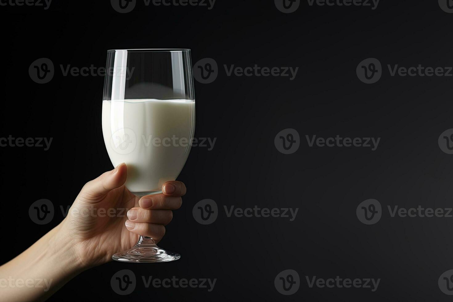Hand holding a glass of fresh milk isolated on black background with copy space. ai generated photo