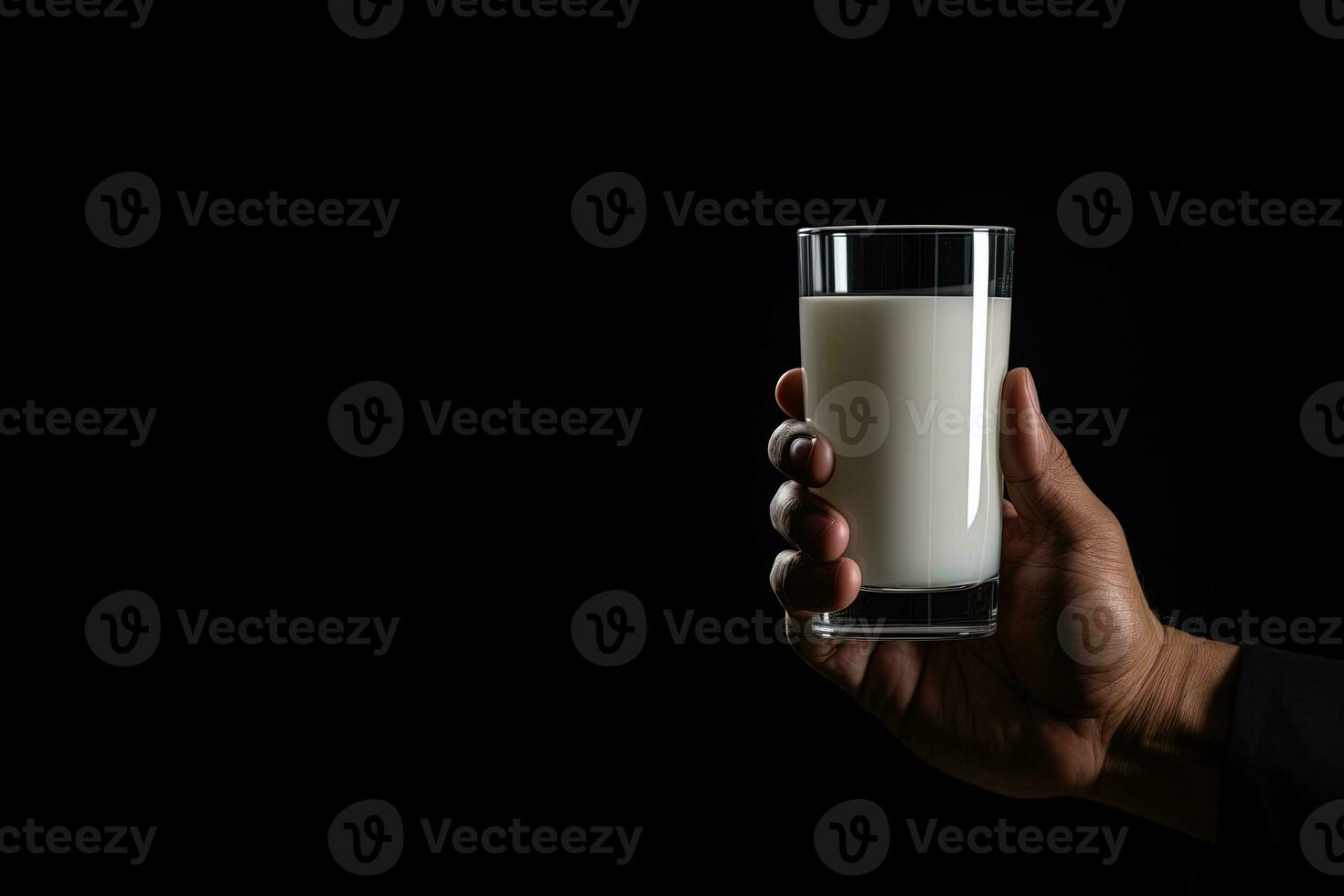 Hand holding a glass of fresh milk isolated on black background with copy space. ai generated photo