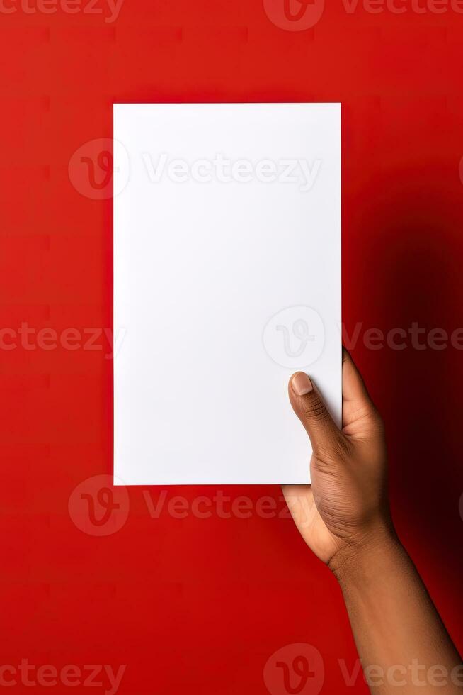 A human hand holding a blank sheet of white paper or card isolated on red background. ai generated photo