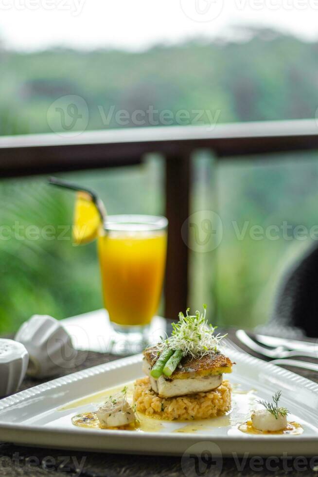 un plato de comida en un mesa con un vaso de naranja jugo foto