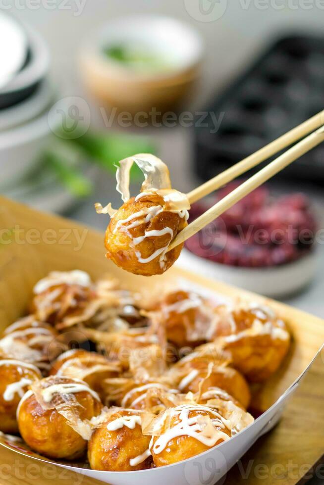 un caja de takoyaki con palillos foto