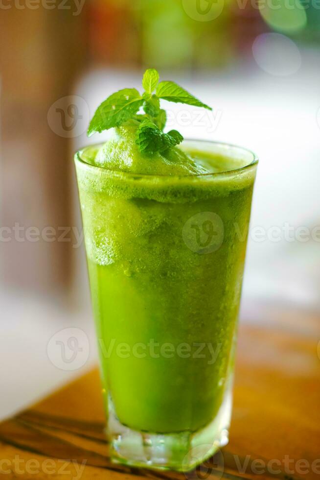 un vaso de verde jugo foto