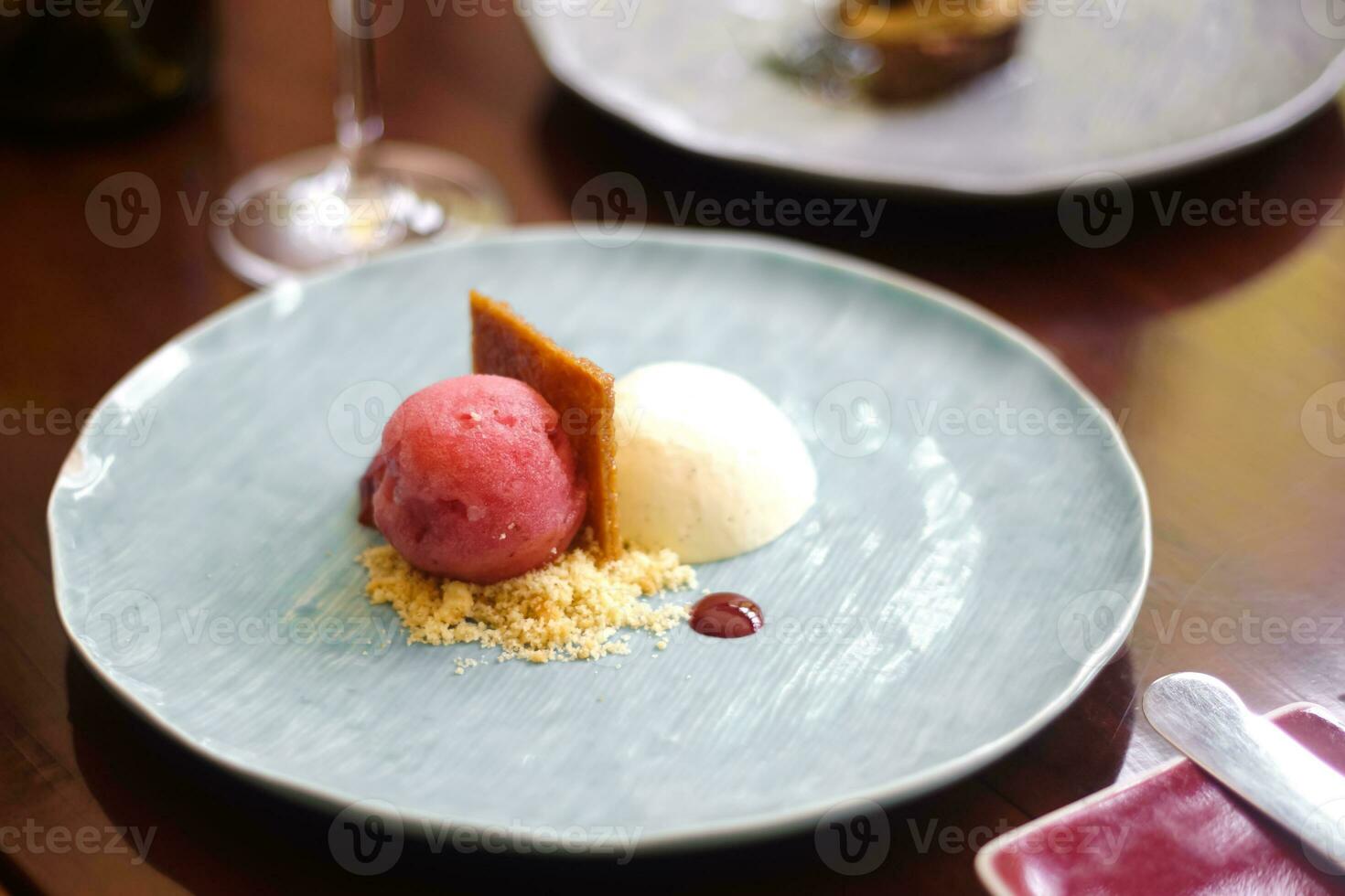 un plato con un postre en eso y un vaso de vino foto