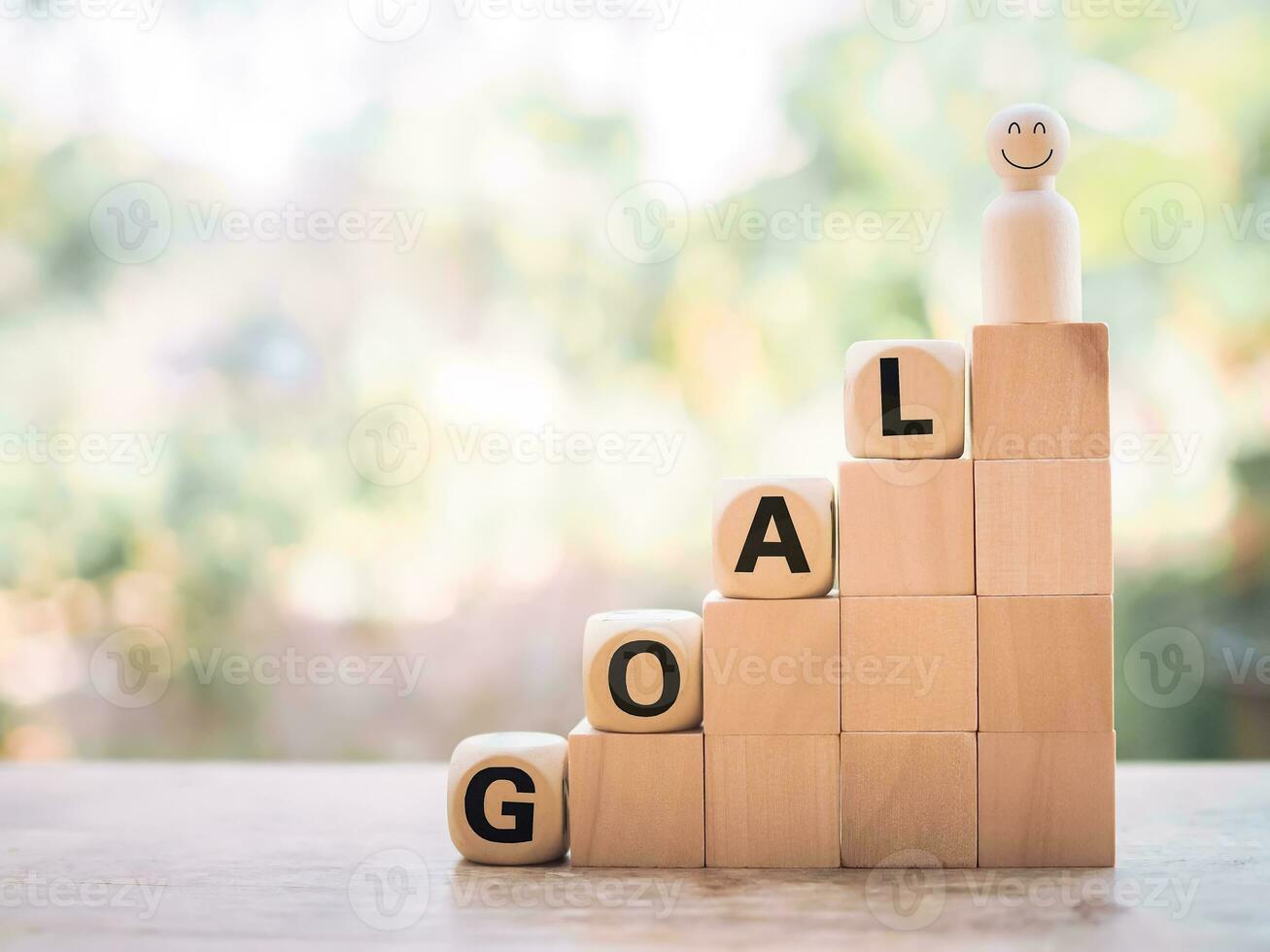 Wooden human figure and wooden blocks with the word GOAL, The concept of business strategy for success and winner concept photo