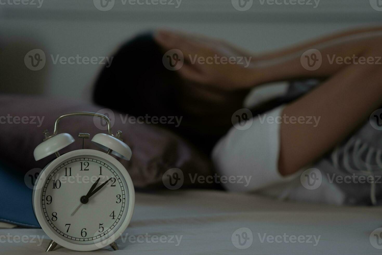 asian woman in bed late trying to sleep suffering insomnia, sleepless or scared in a nightmare, looking sad worried and stressed. Tired and headache or migraine waking up in the middle of the night. photo