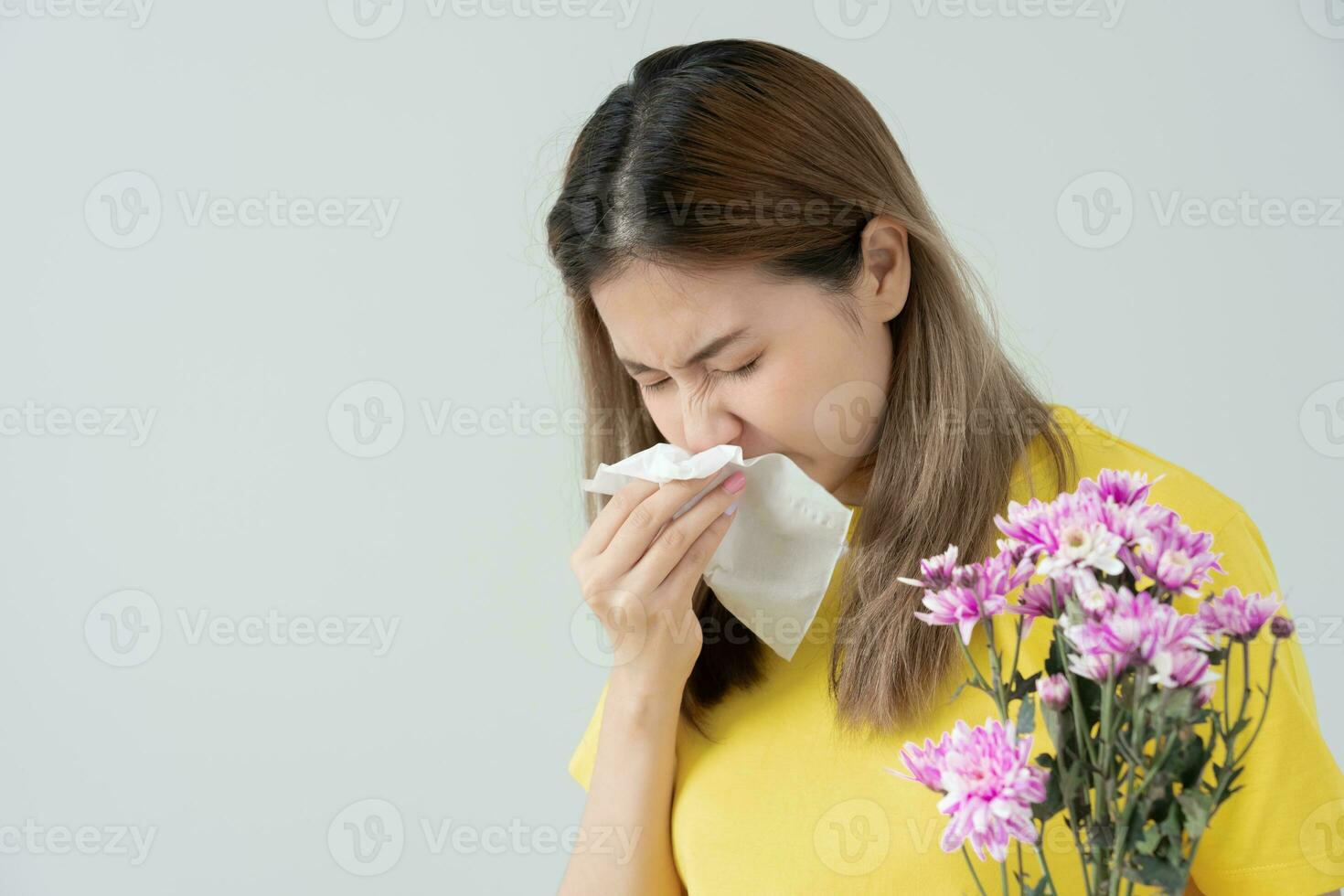 polen alergias, asiático joven mujer estornudos en un pañuelo o soplo en un limpiar, alérgico a salvaje primavera flores o flores durante primavera. alérgico reacción, respiratorio sistema problemas foto