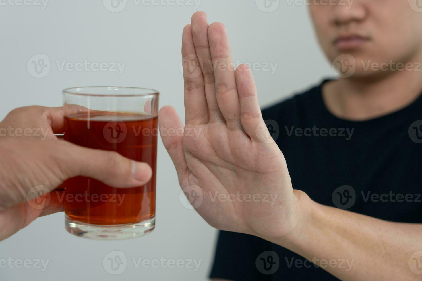 man refuses say no and avoid to drink an alcohol whiskey , stopping hand sign male, alcoholism treatment, alcohol addiction, quit booze, Stop Drinking Alcohol. Refuse Glass liquor, unhealthy, reject photo