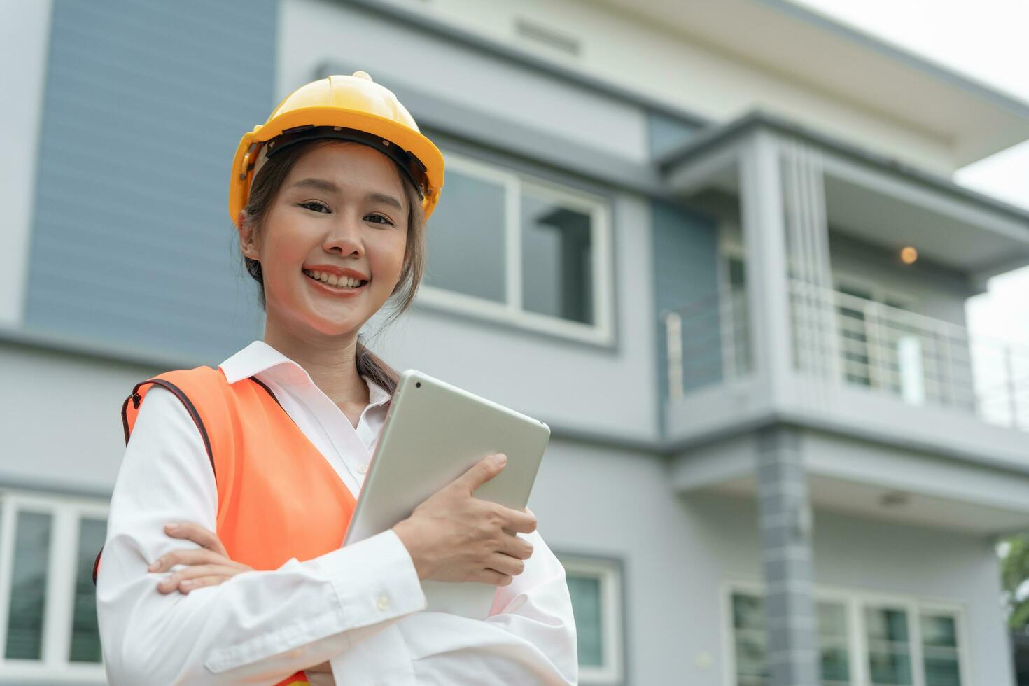 inspector, ingeniero, capataz o contratista se cruza orgulloso de brazos para inspeccionar la calidad de su trabajo. los arquitectos trabajan para construir la casa antes de entregársela al propietario. desarrollar nueva finca. foto