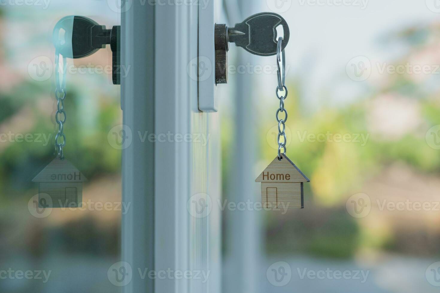 Landlord key for unlocking house is plugged into the door. Second hand house for rent and sale. keychain is blowing in the wind. mortgage for new home, buy, sell, renovate, investment, owner, estate photo