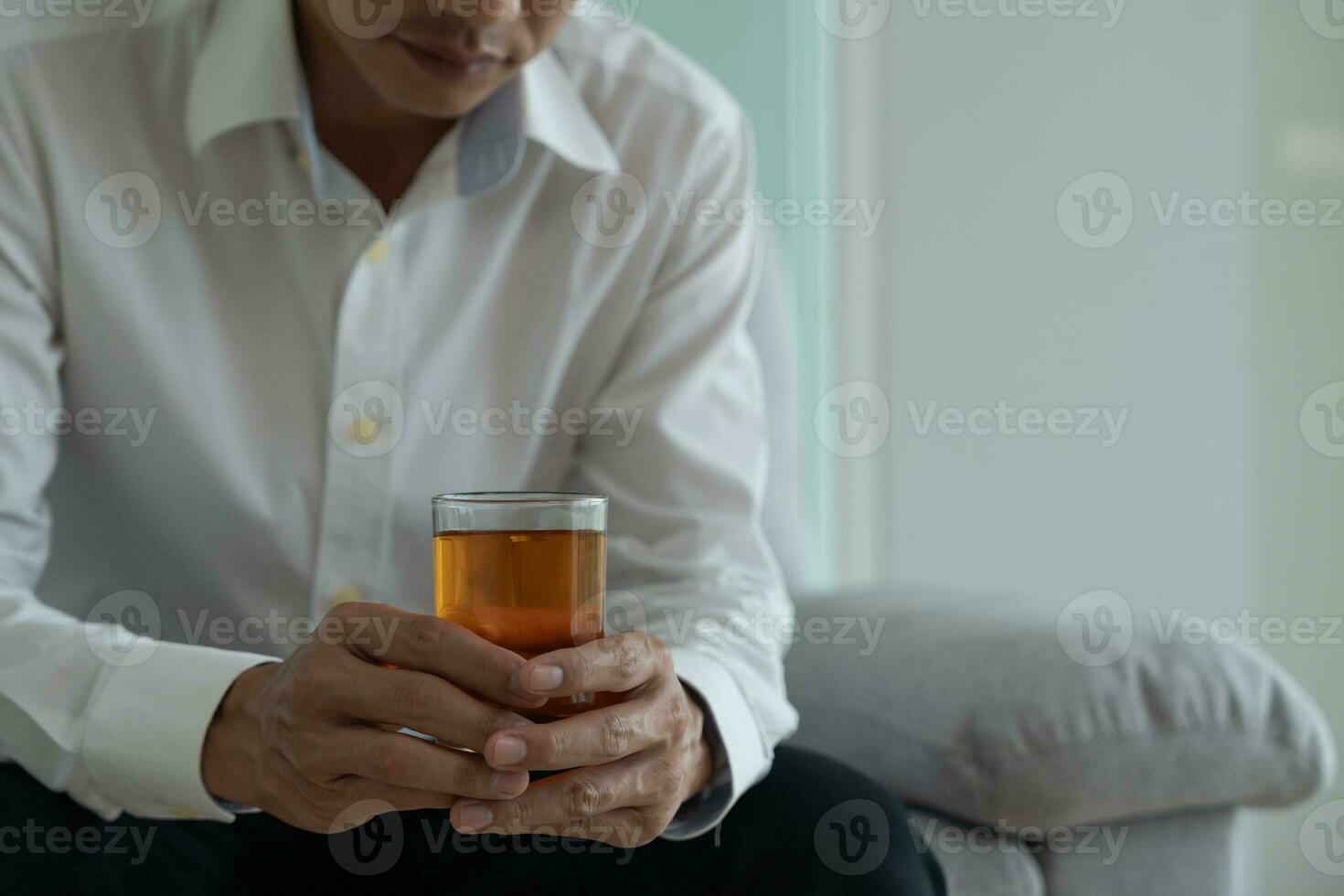 Depressed young business man addicted feeling bad drinking whiskey alone at home, stressed frustrated lonely drinking alcohol suffers from problematic liquor, alcoholism, life and family problems photo