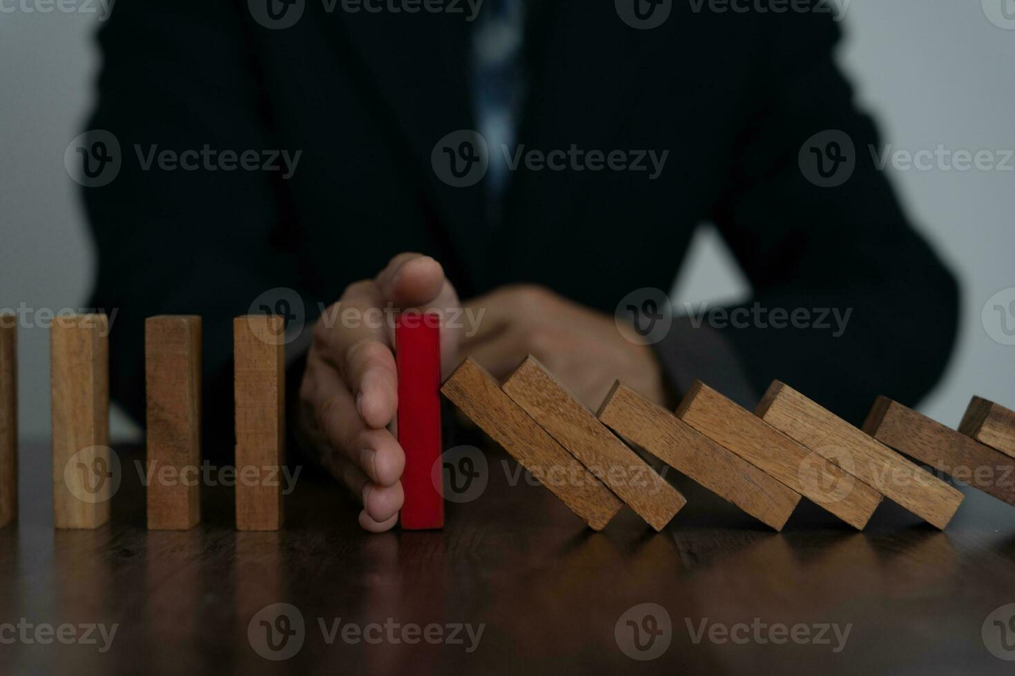 insurance with hands protect domino. Businessman hands stop dominoes falling in business crisis. business risk control and planning and strategies to run prevent insurance businesses. photo