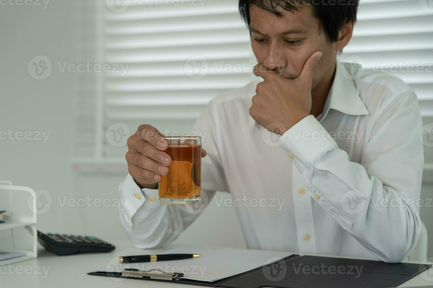 Depressed young business man addicted feeling bad drinking whiskey alone at home, stressed frustrated lonely drinking alcohol suffers from problematic liquor, alcoholism, life and family problems photo