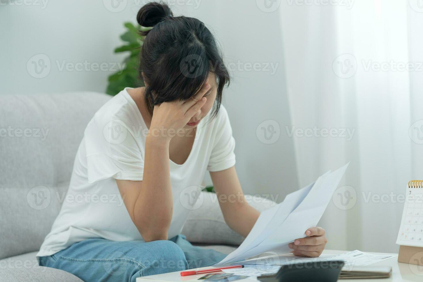 Stressed and headache asian woman with large bills or invoices no money to pay to expenses and credit card debt. shortage, Financial problems, mortgage, loan, bankruptcy, bankrupt, poor, empty wallet photo