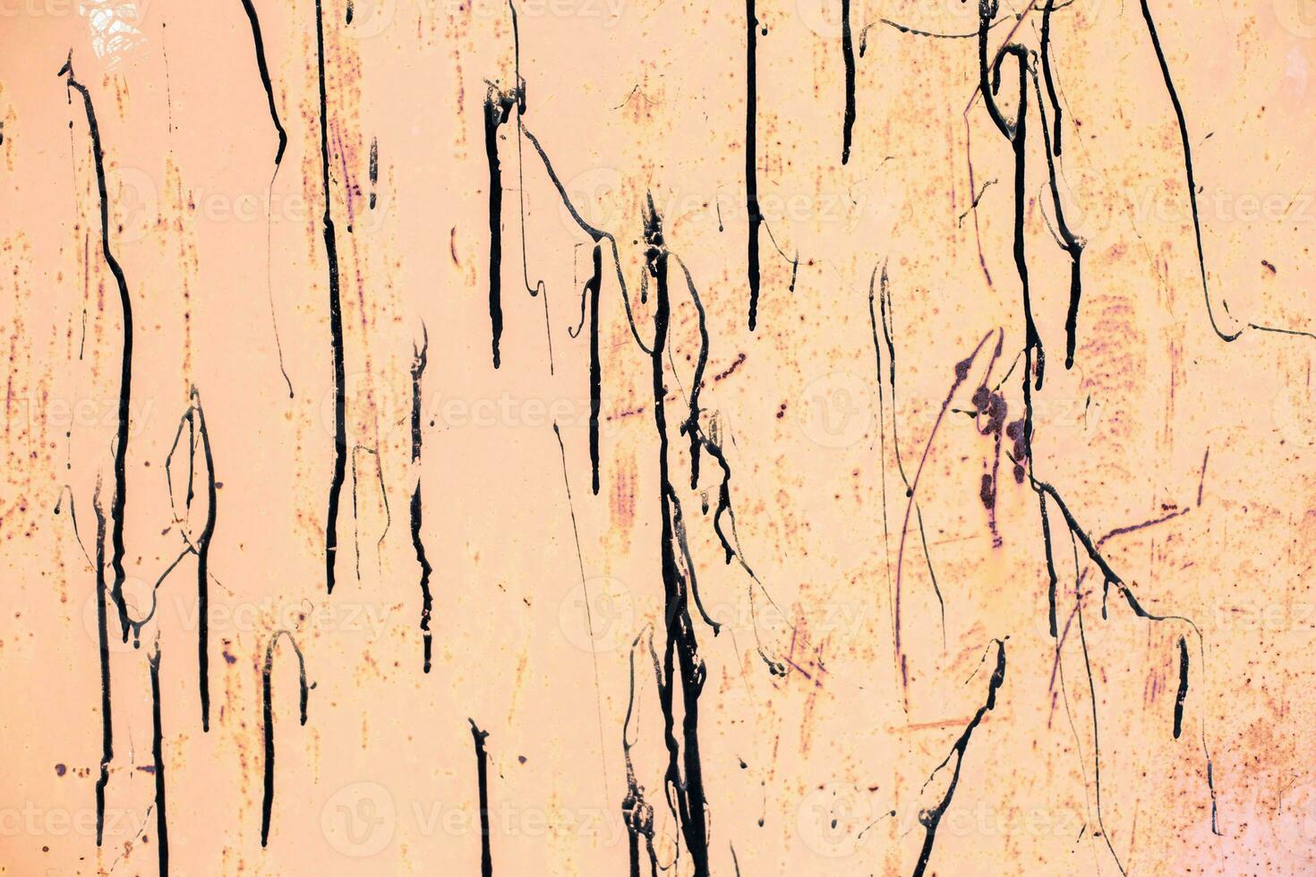 Old beige rusty sheet metal smeared with black tar. pastel pink shabby rusty metal surface. photo