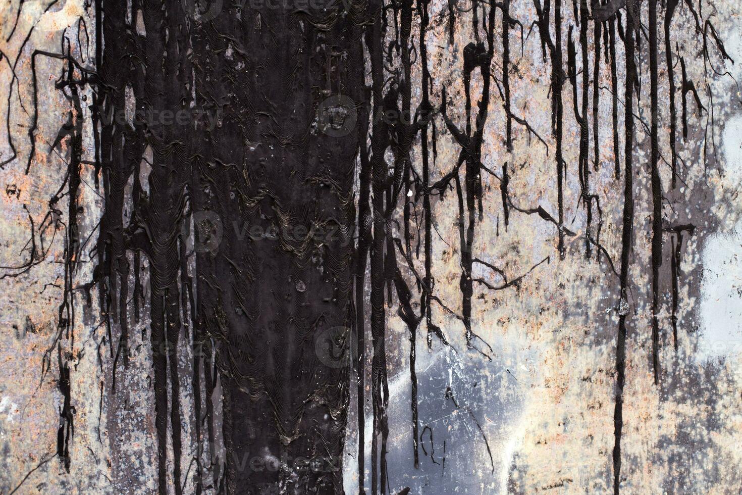 Old rusty sheet metal smeared with black tar. Dark shabby rusty metal surface. photo